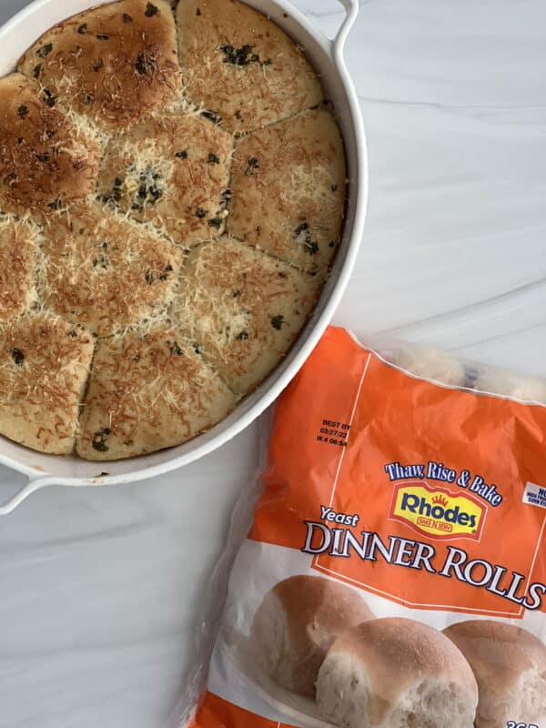 a dish of garlic Parmesan dinner rolls in an oval dish with a package of rolls next to it.