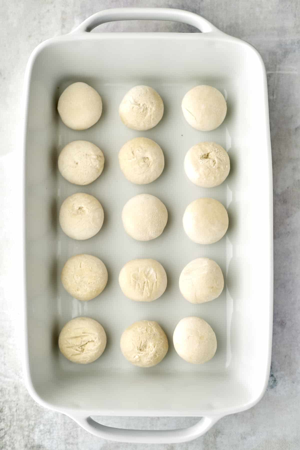 raw bread rolls in a baking dish