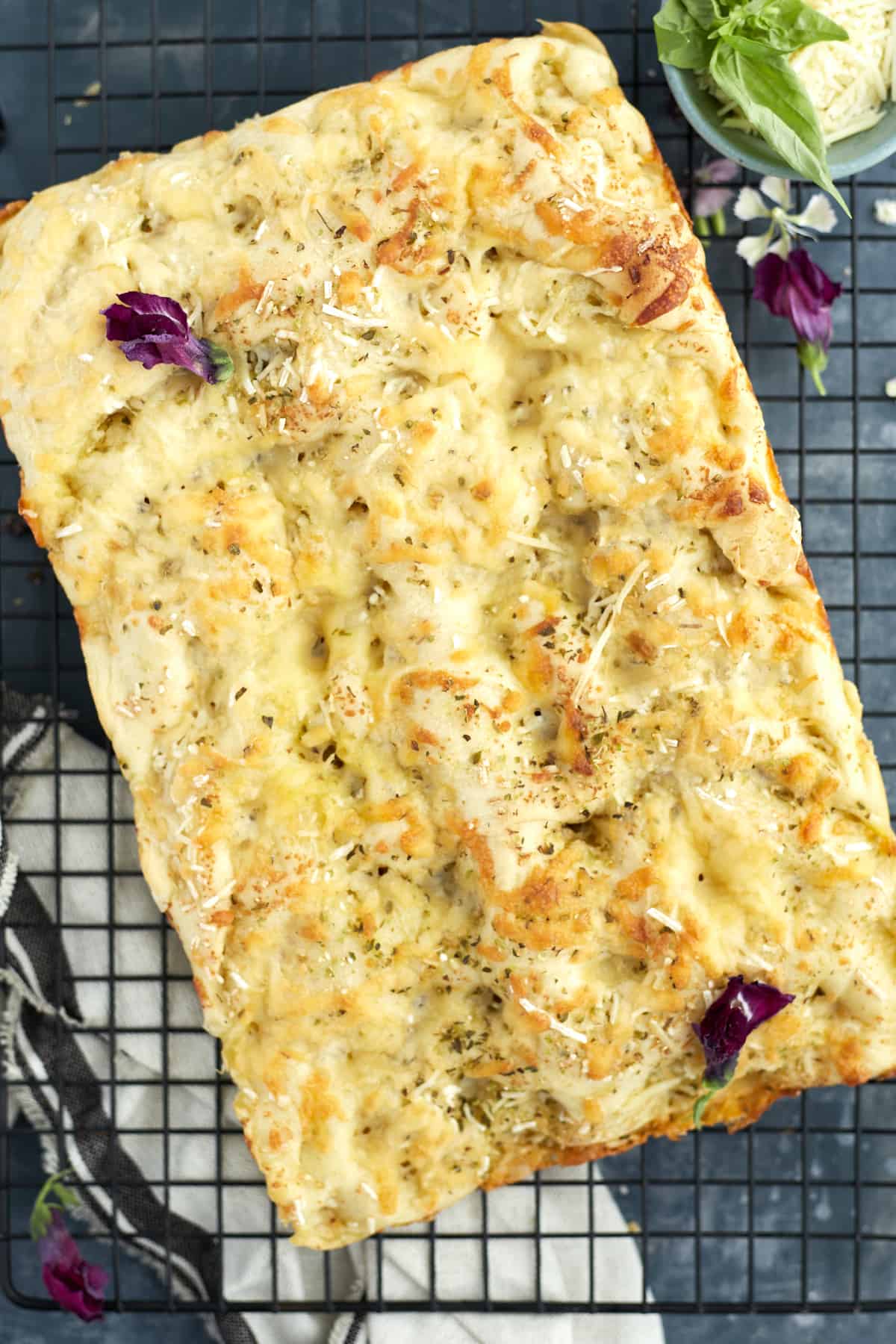 no knead focaccia bread garnished with fresh basil and flowers