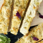 no knead focaccia bread sliced diagonally on a cutting board.