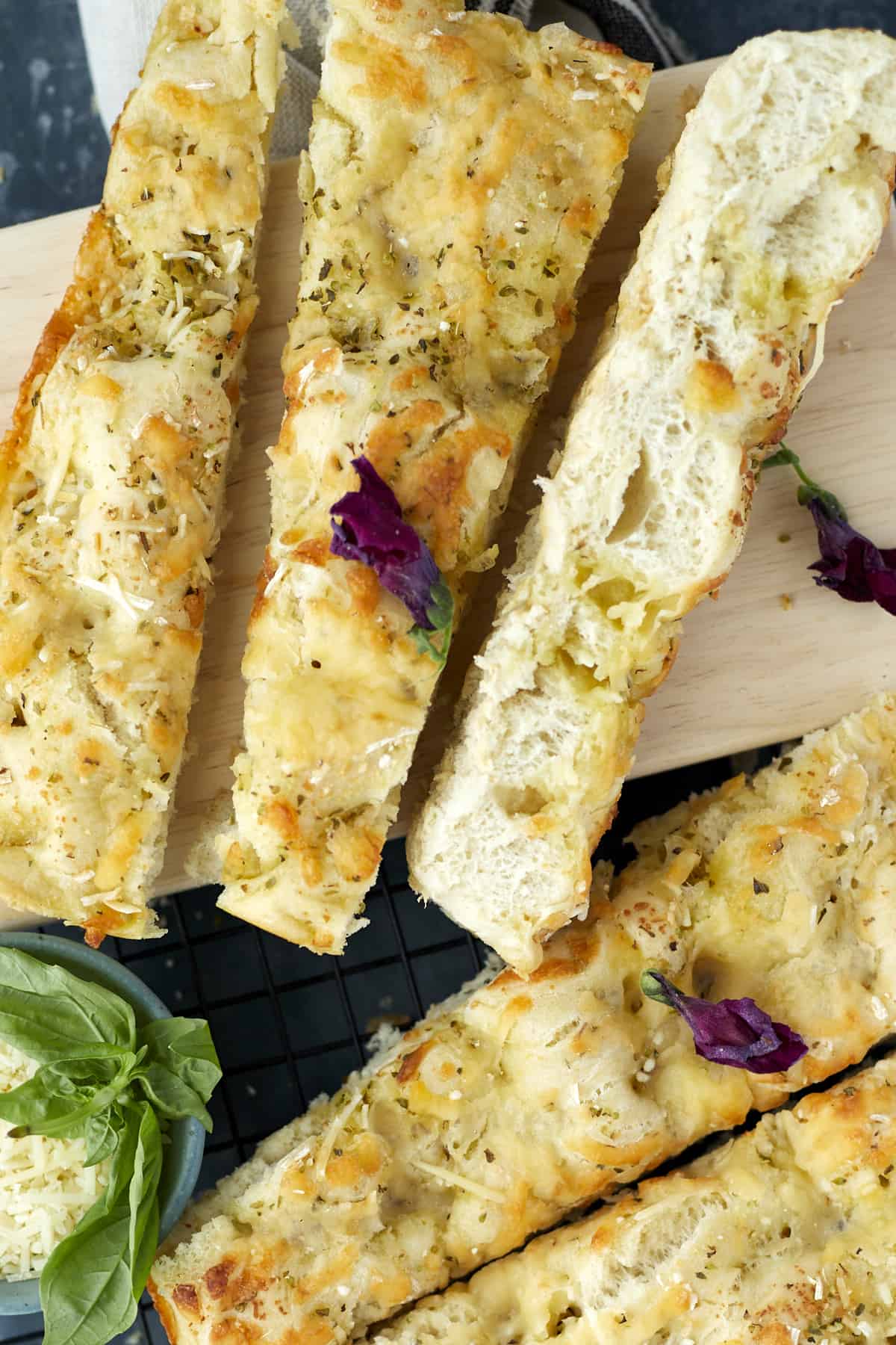 no knead focaccia bread sliced diagonally on a cutting board.