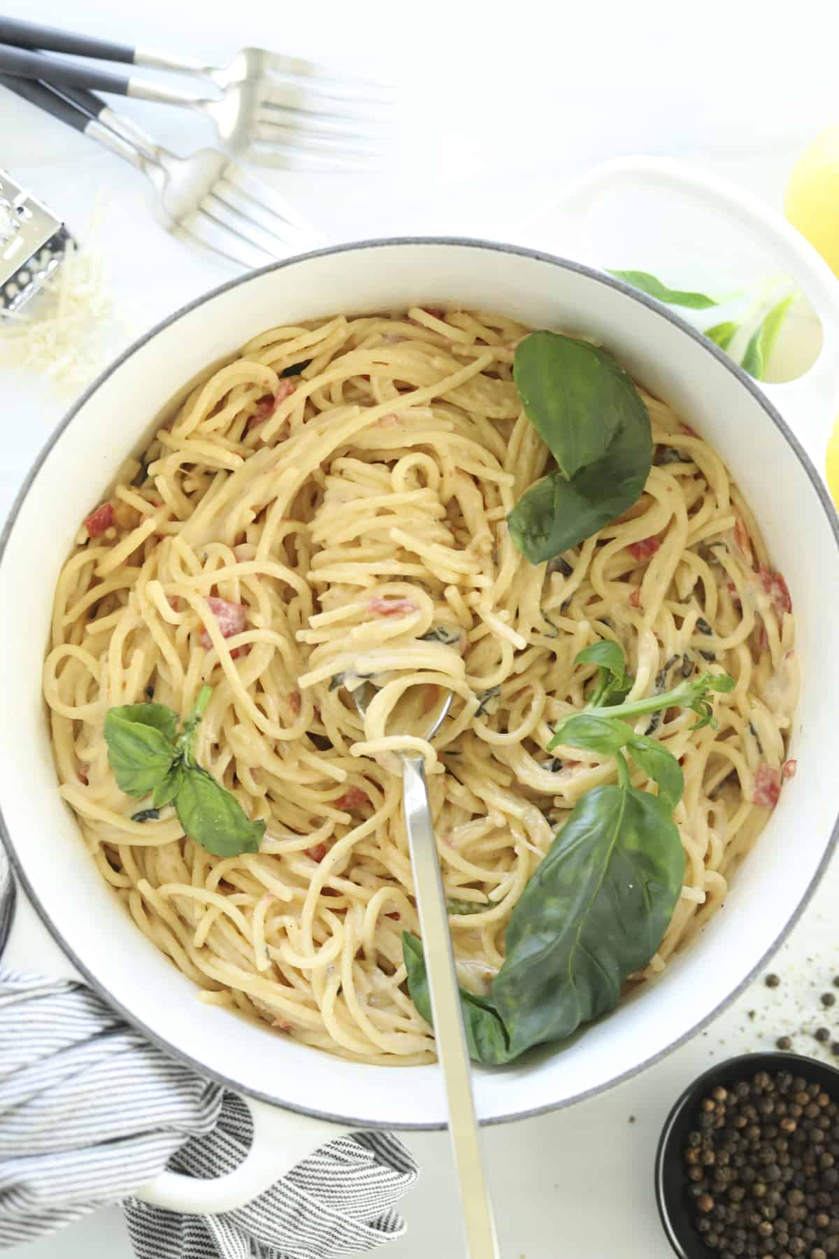 overhead image of one pot parmesan pasta topped with fresh herbs being twirled with a fork