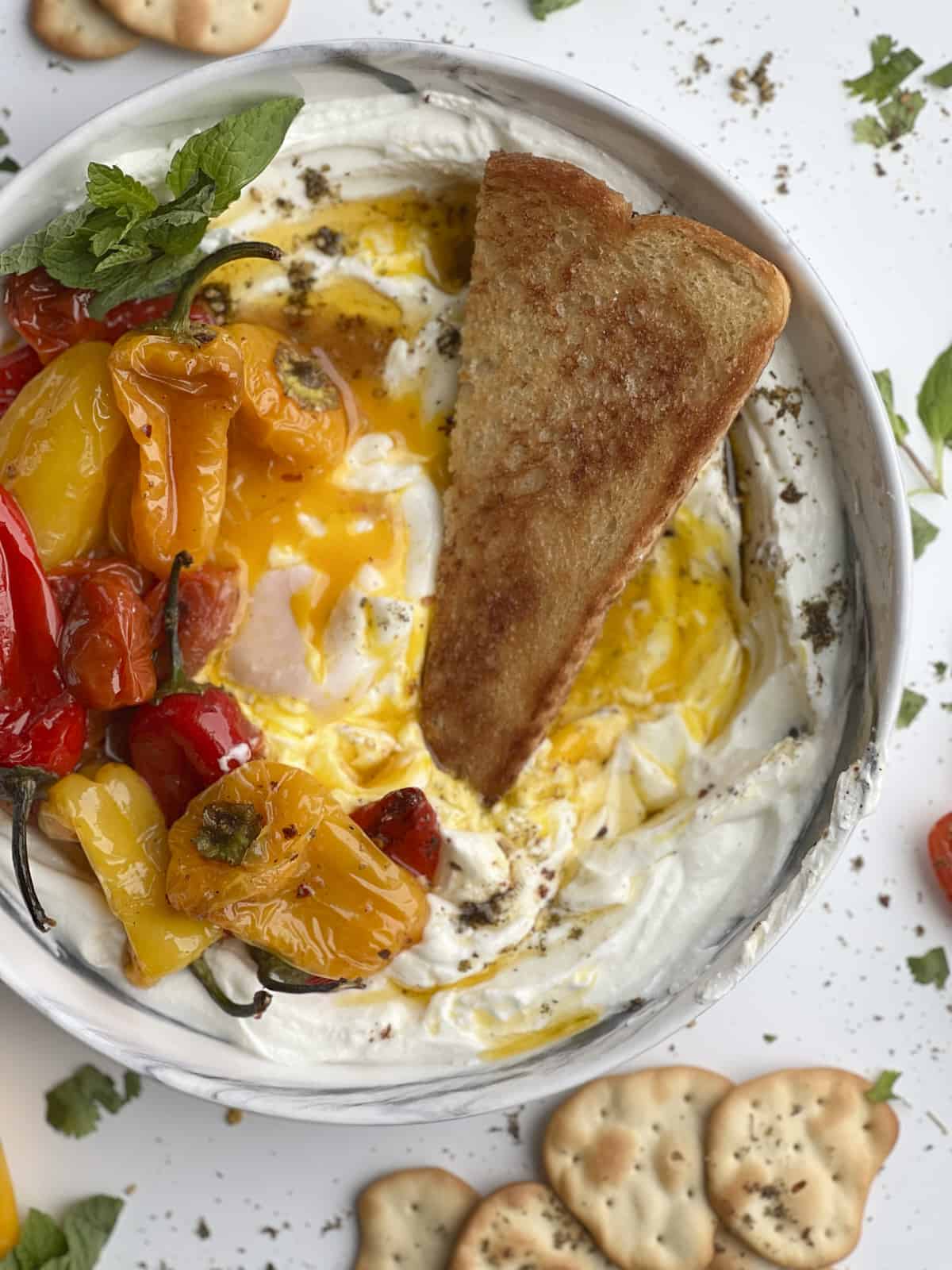 turkish eggs dish with yogurt, toast, and roasted peppers and tomatoes
