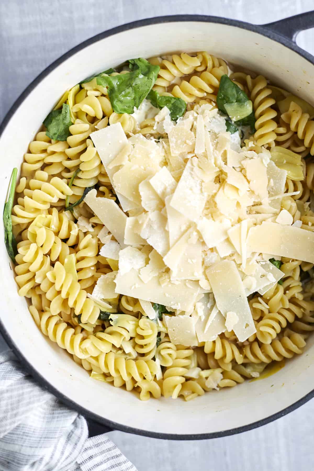 one pot spinach and artichoke pasta topped with Parmesan flakes