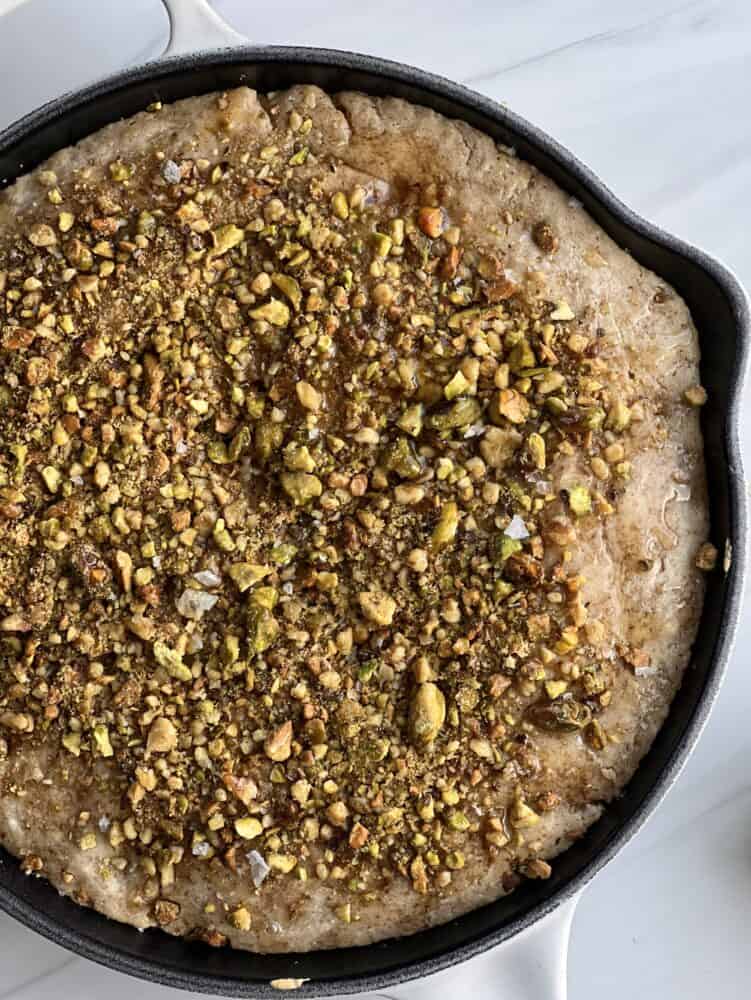 a skillet full of baklava pancake topped with pistachios
