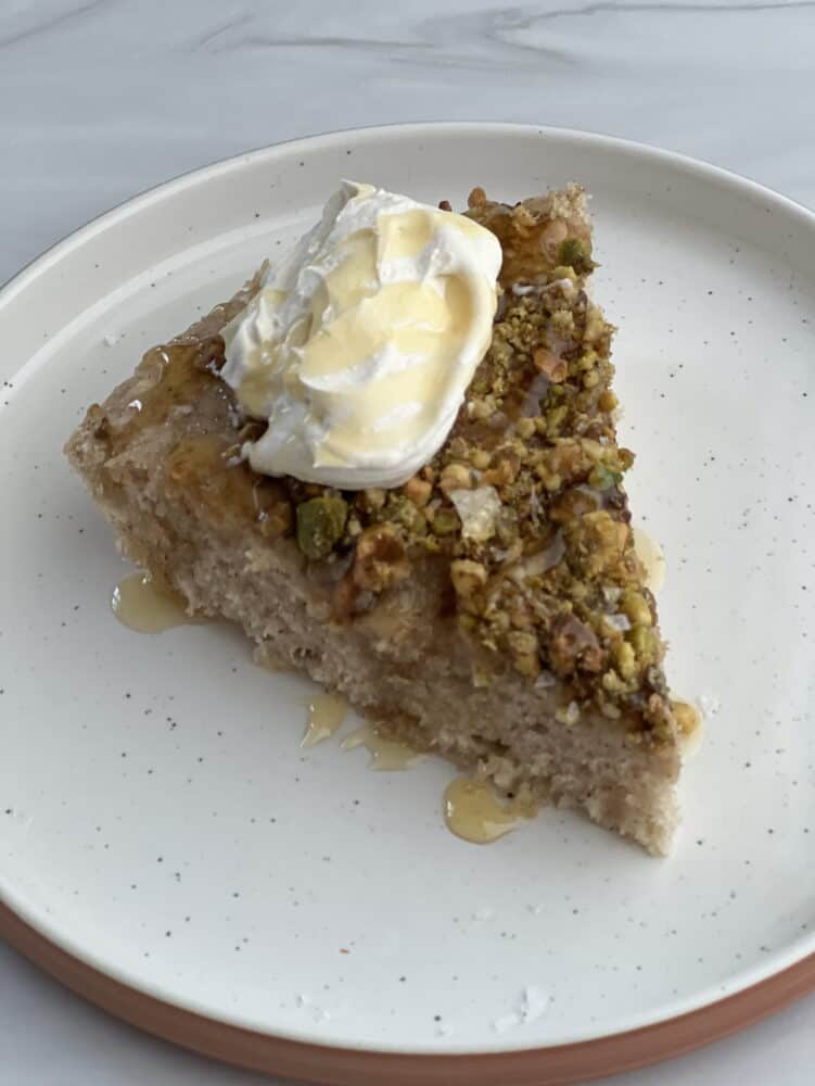 a slice of baklava skillet pancake on a plate topped with creme fraiche and a drizzle of honey
