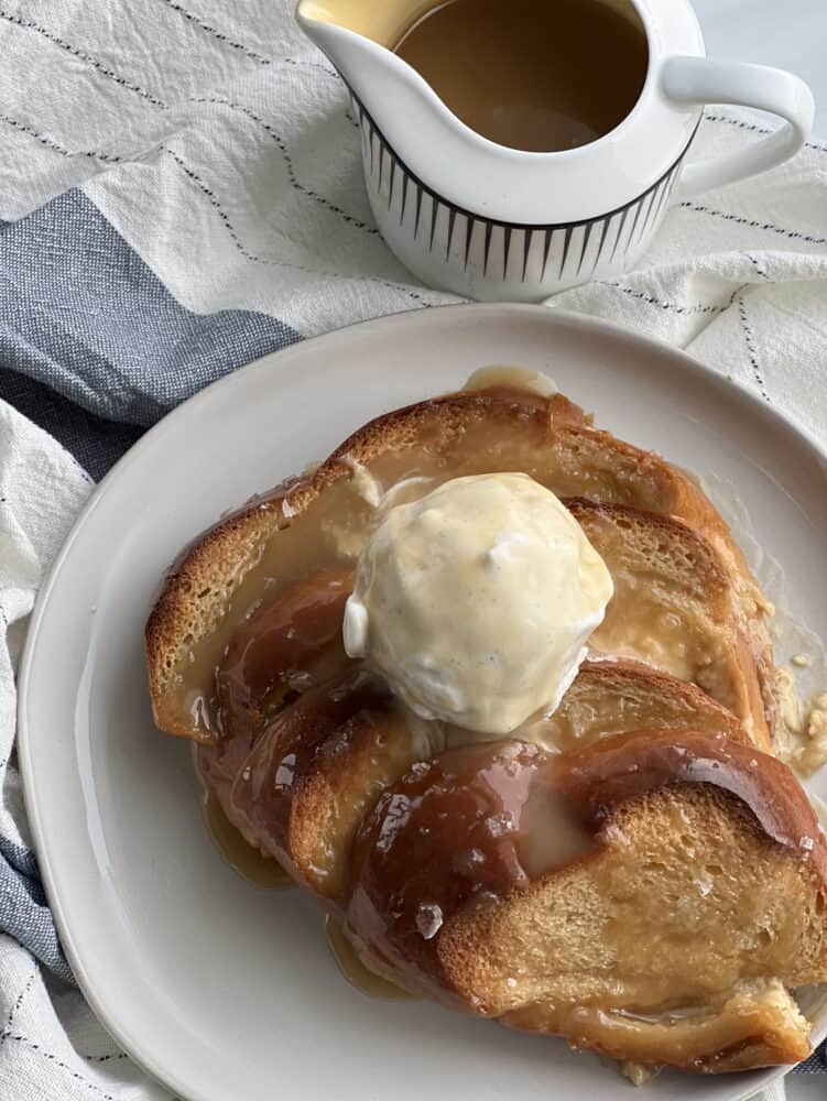 a serving of salted caramel bread pudding topped with vanilla ice cream