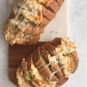 two loaves of cheesy garlic bread sliced into pull apart bread