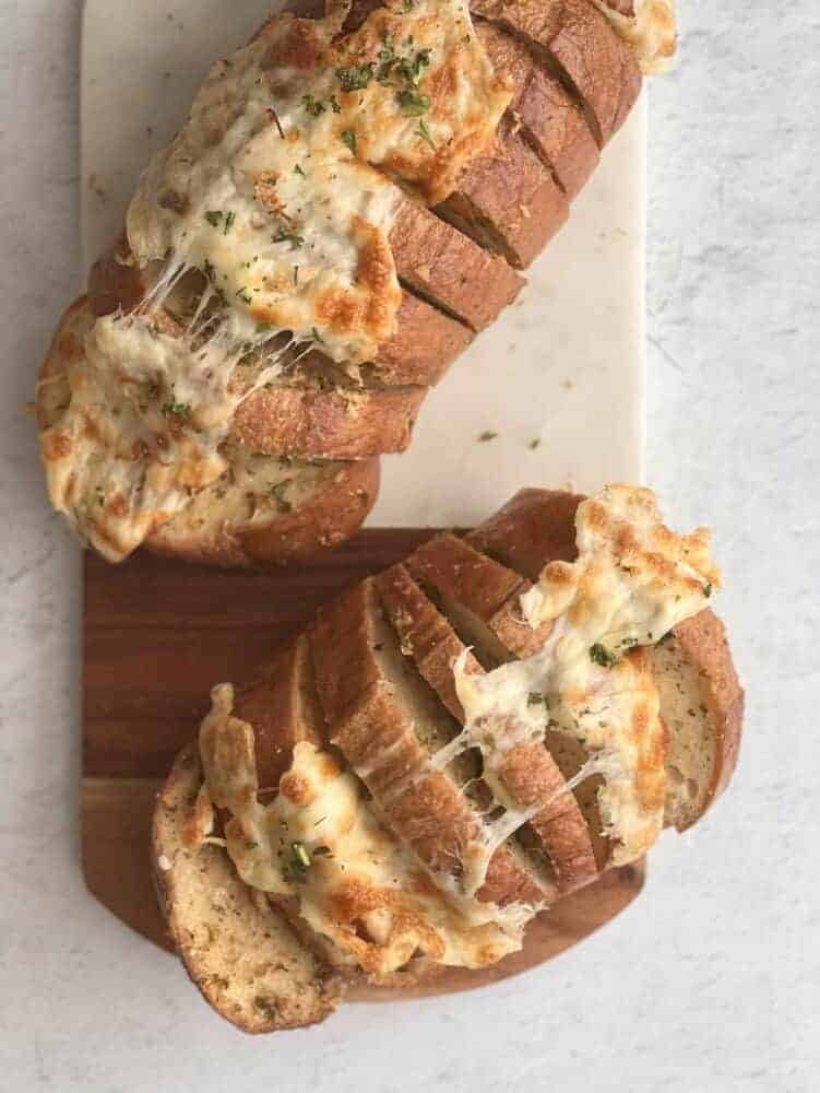 cheesy garlic bread split into two pull apart bread loaves