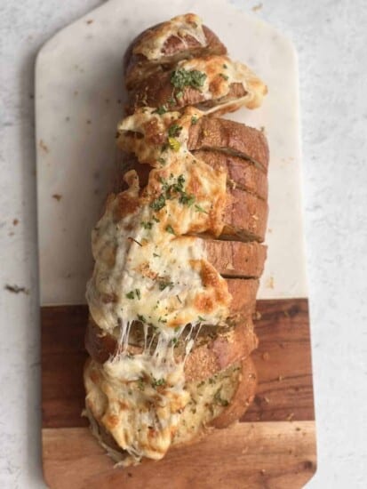 overehead image of cheesy garlic bread sliced into pull apart bread