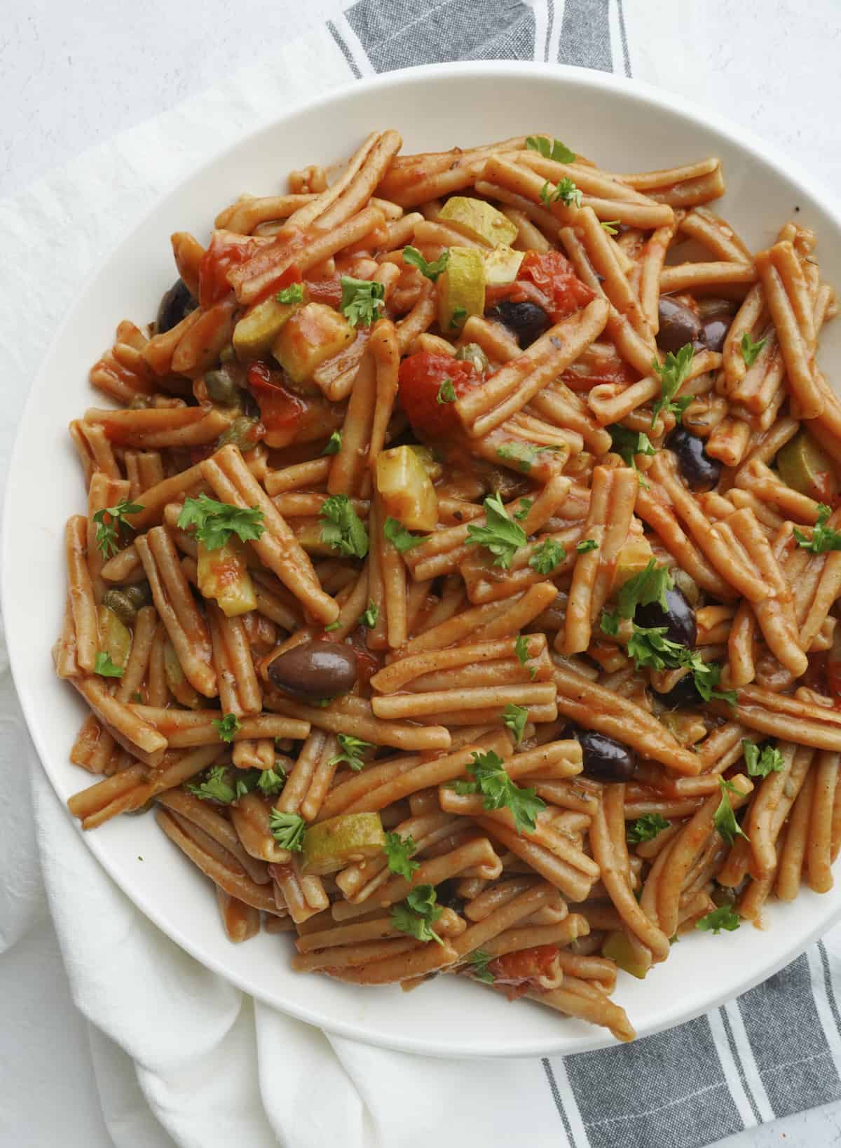 a bowl of one pot pasta puttanesca with whole wheat pasta