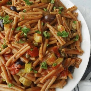 a plate of one pot pasta puttanesca with whole wheat pasta