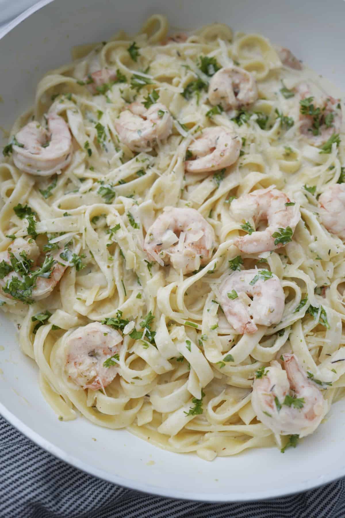 overhead of shrimp linguine with fresh parsley in a bowl