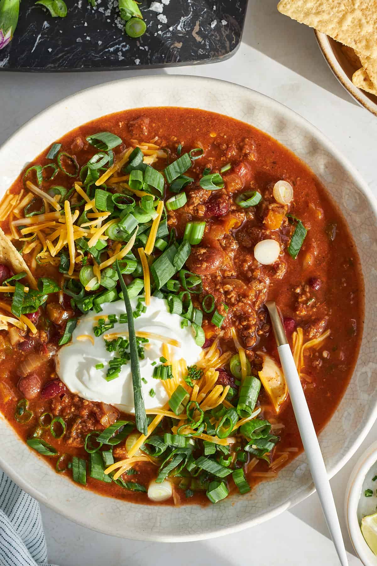 A bowl of slow cooker chili with a spoon sticking out. 