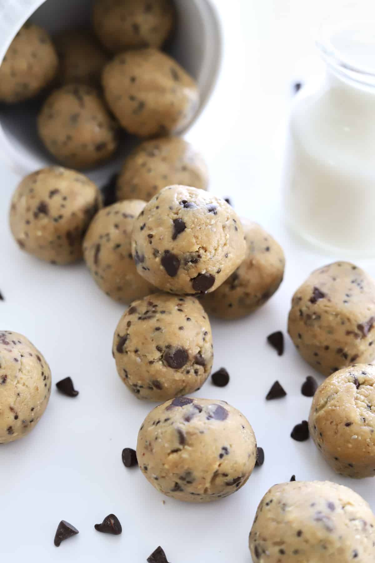 peanut butter energy balls spilling out of a cup with chocolate chips.