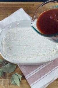 marinara being poured over a cheese mixture