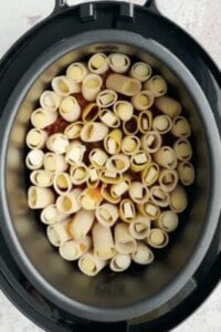 uncooked noodles stuffed with cheese over marinara sauce in a pressure cooker