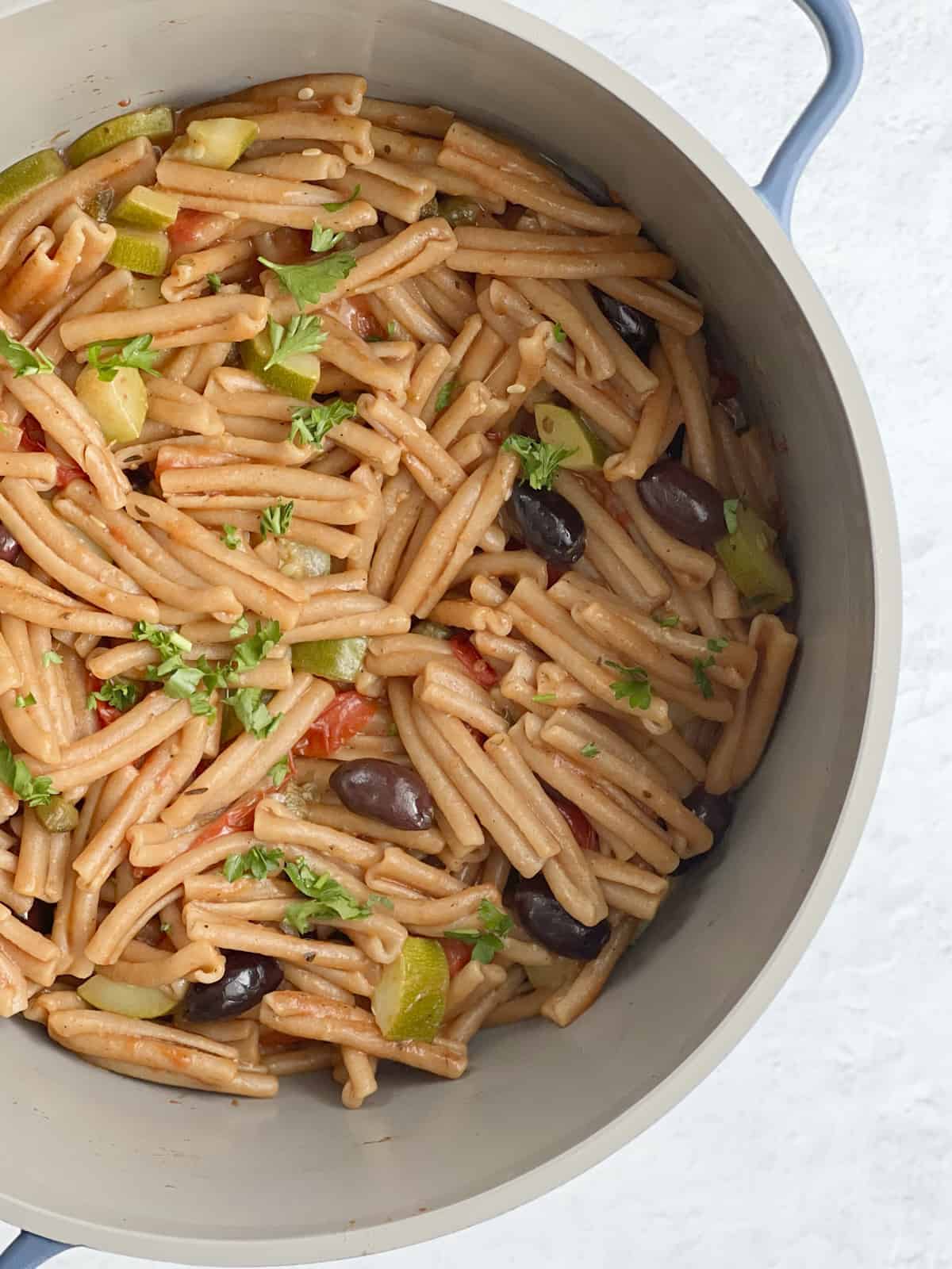 a pot of pasta puttanesca with whole wheat pasta