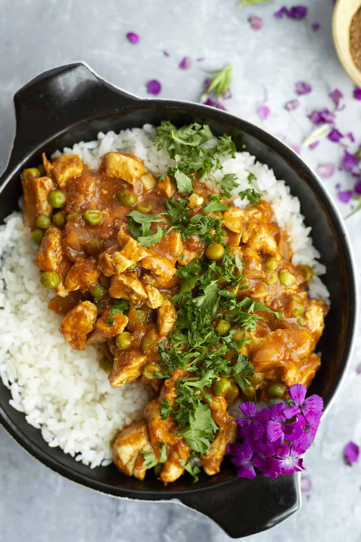 overhead madras curry chicken in a bowl with rice and cilantro