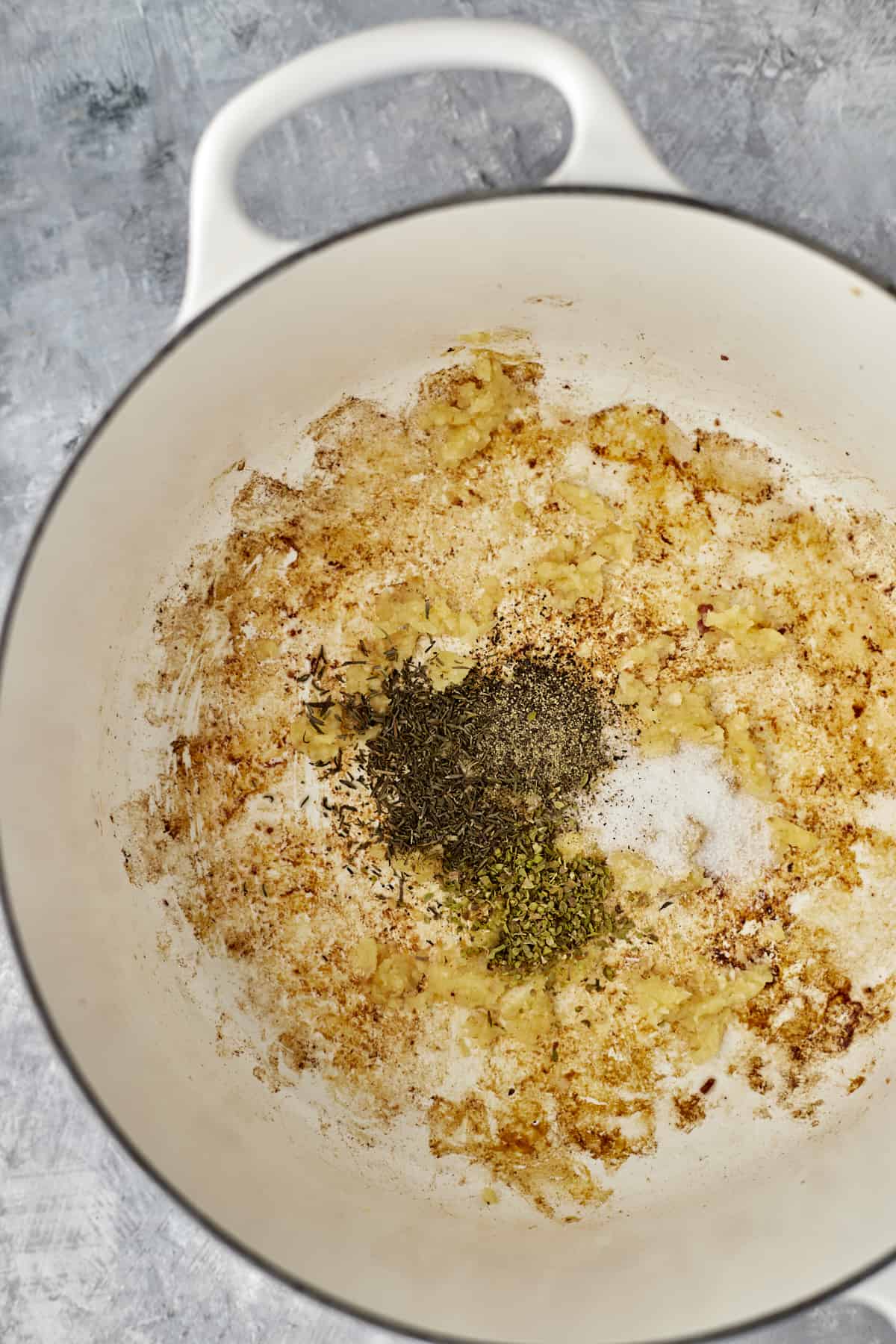 onions sautéing in the bottom of a white pot