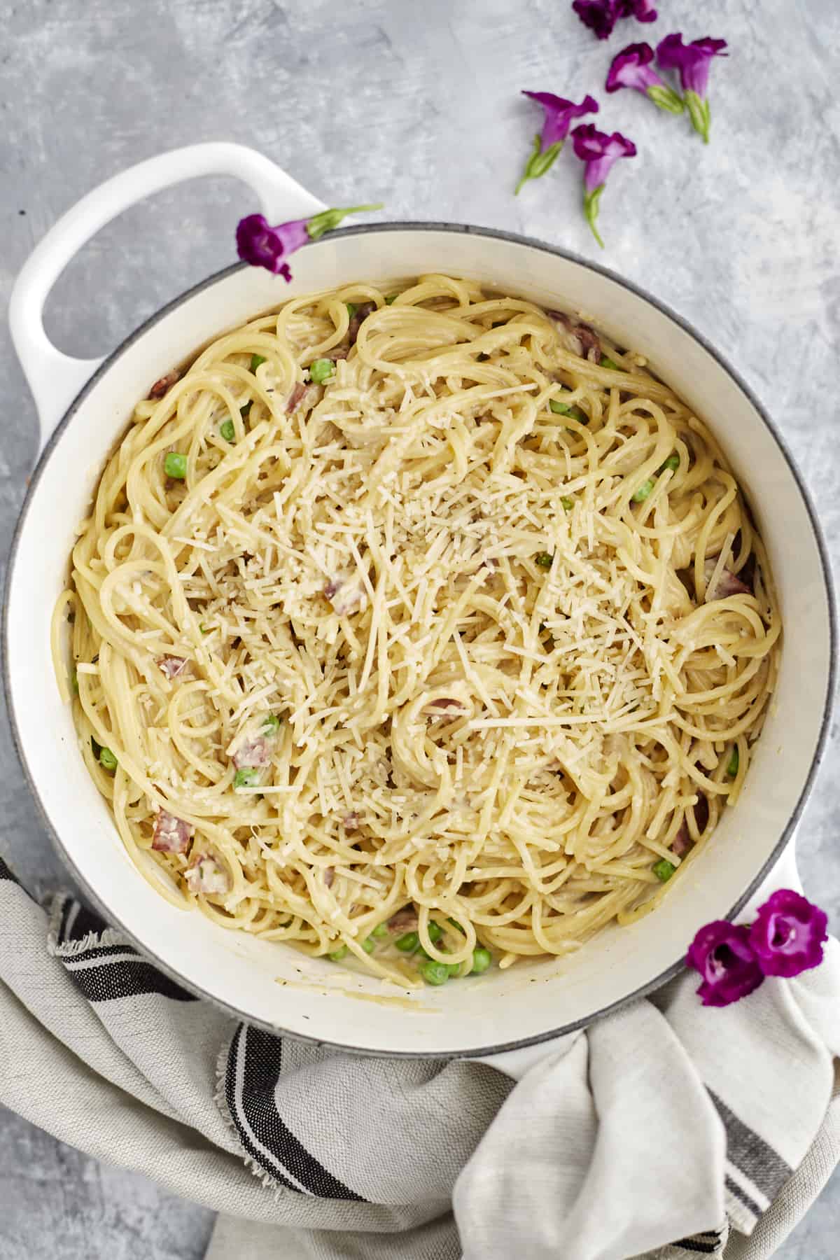 one pot spaghetti carbonara in a white pot topped with parmesan cheese