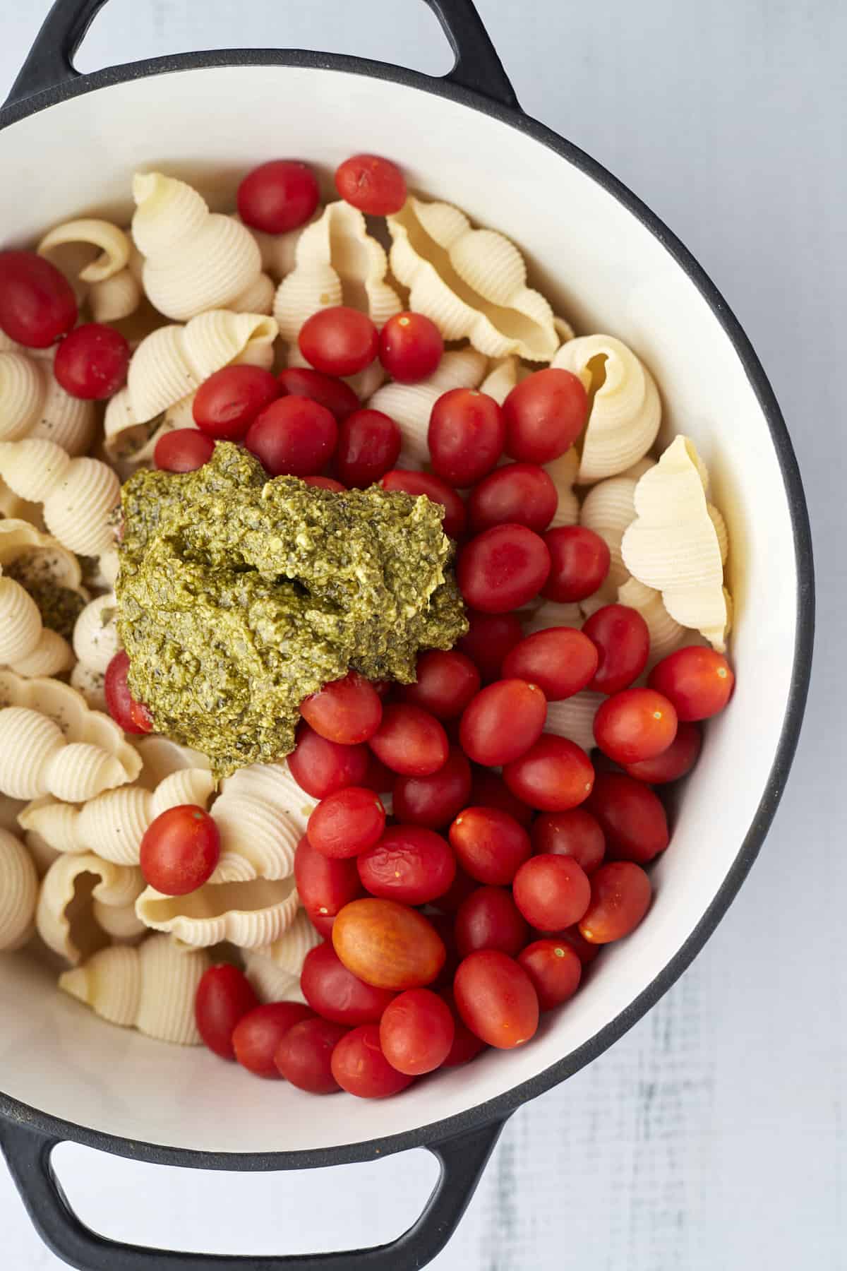 pasta shells, tomatoes, and pesto in a large pot 