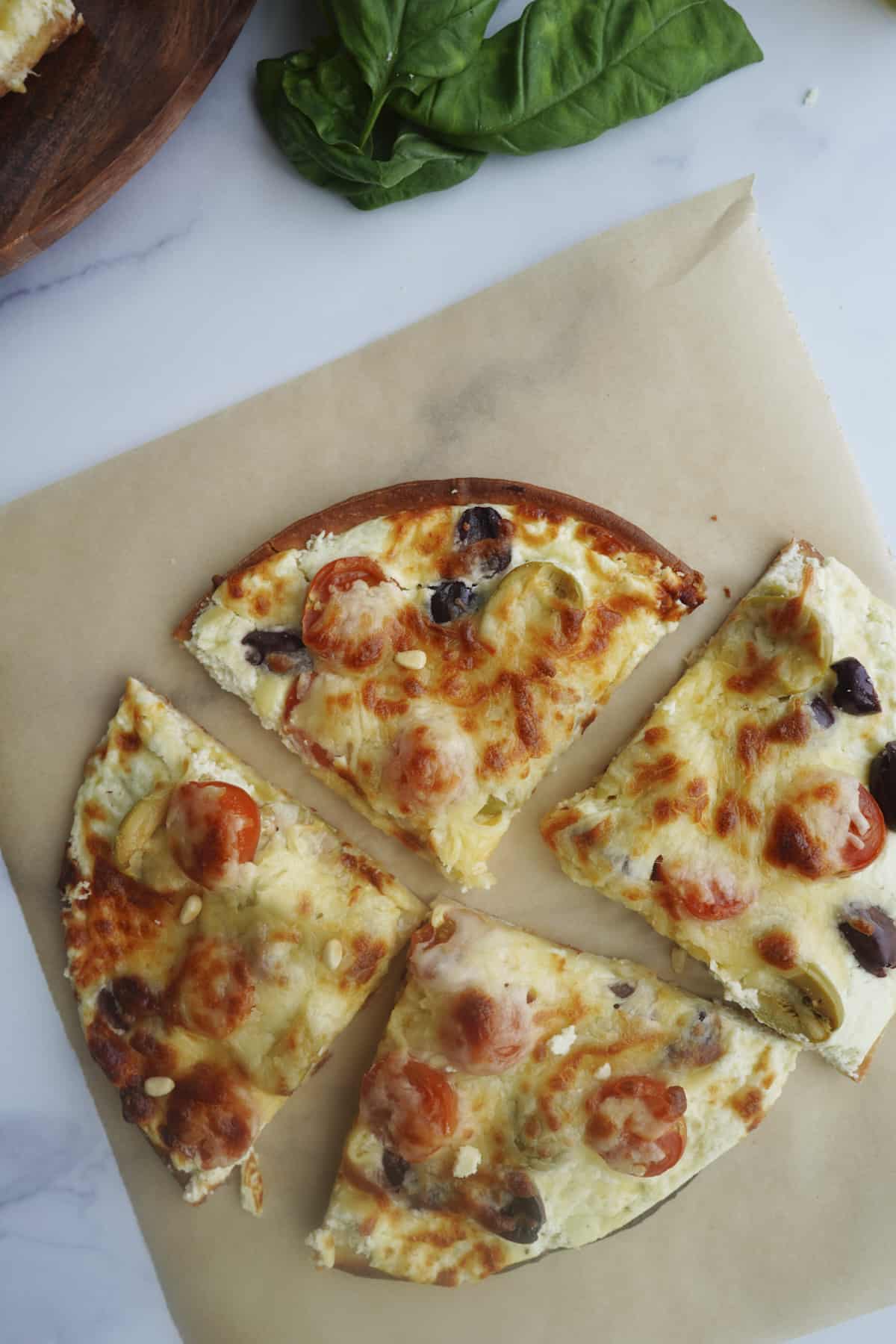 overhead sliced whipped feta pizza with fresh basil.