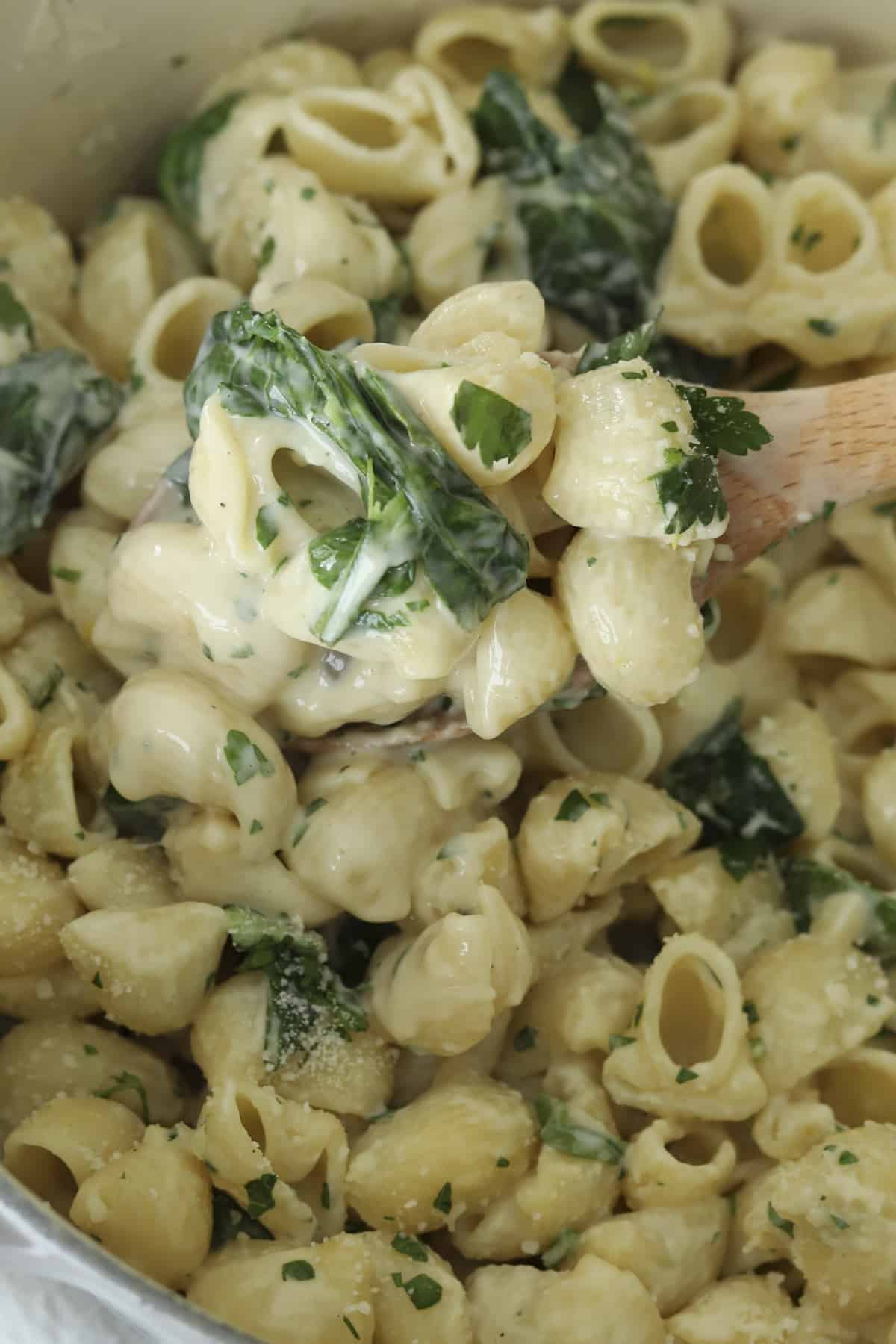 close up overhead image of lemon garlic pasta on wooden spoon