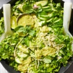 A bowl of green goddess dressing topped with green goddess salad.