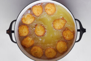Zeppole frying in a pot.