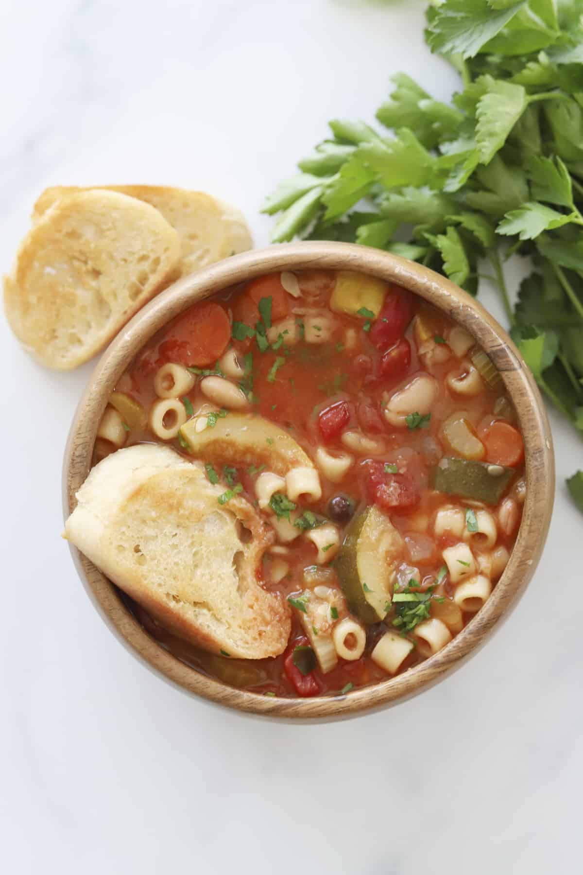 overhead image of a bowl of minestrone soup with toasted crostini