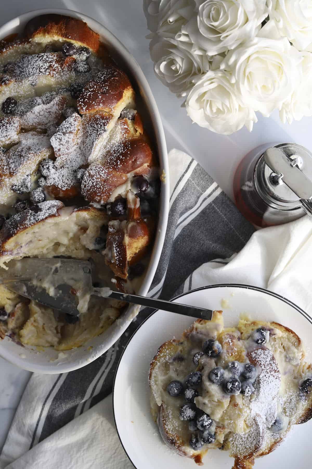 overhead blueberry mascarpone french toast baking dish and plated with powdered sugar 