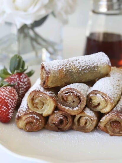 plate of cinnamon roll french toast roll ups with powdered sugar