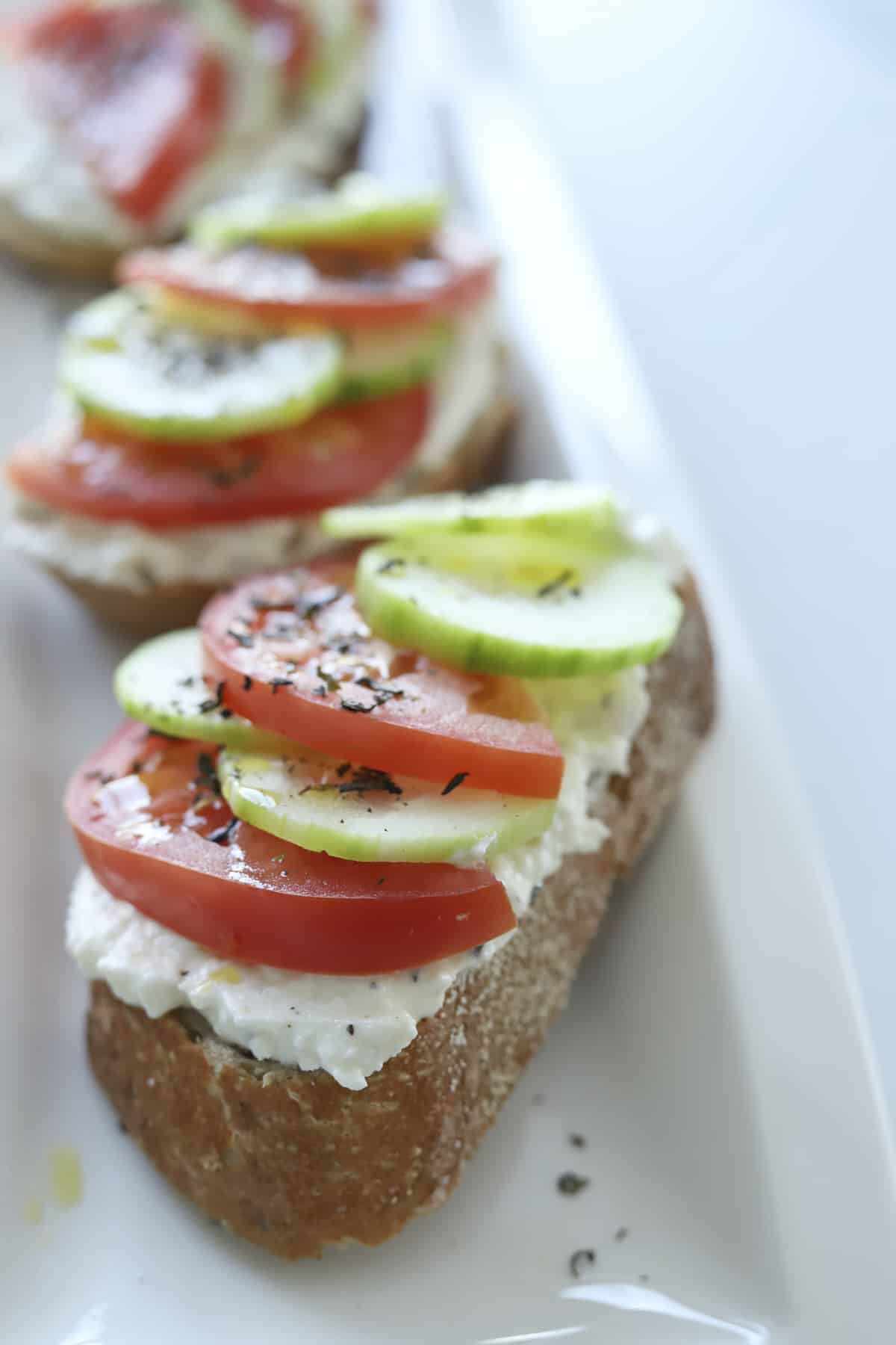 closeup baguette with feta, tomatoes, and cucumbers 
