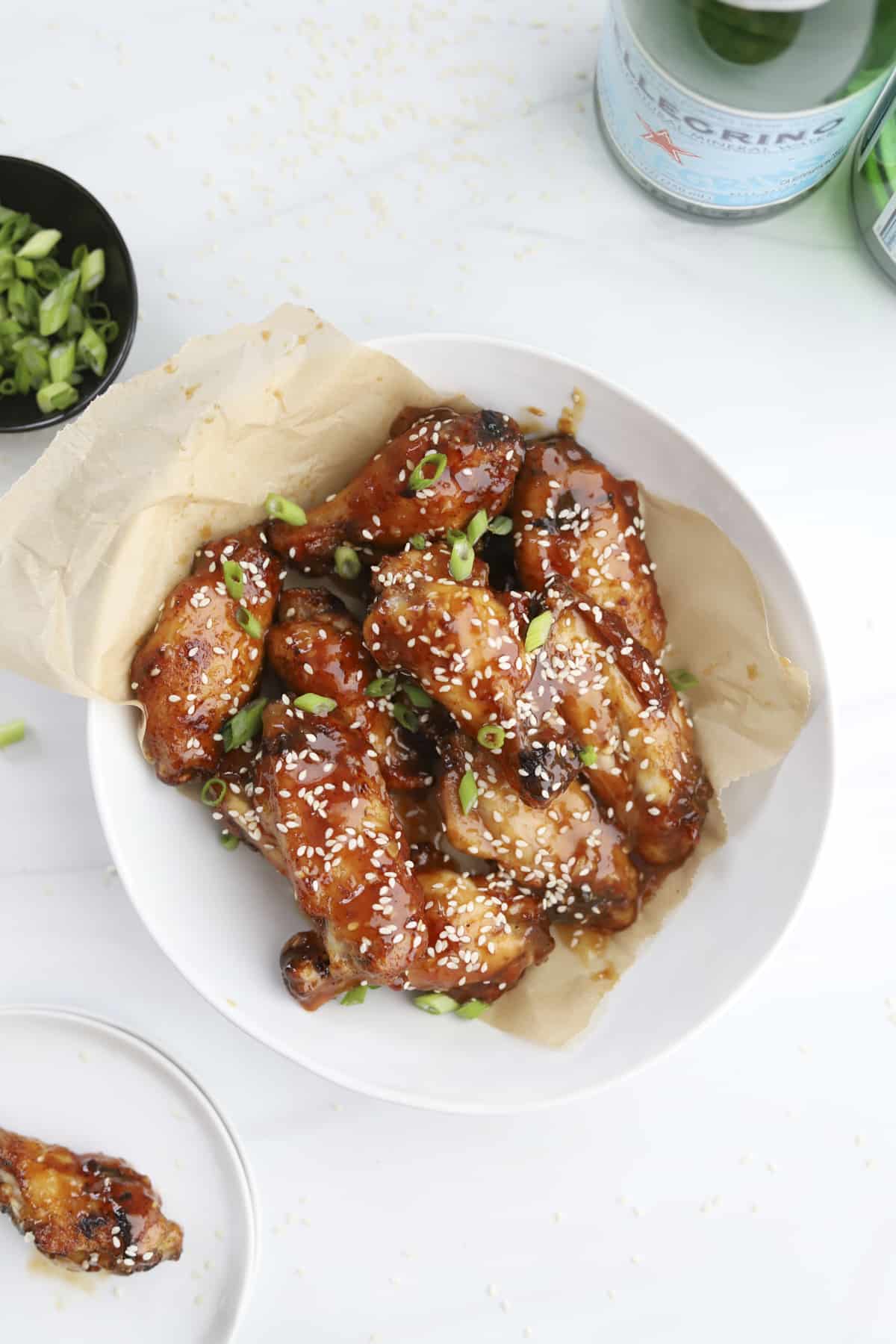 a bowl of air fryer honey garlic chicken wings topped with sesame seeds