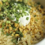 pasta topped with corn, herbs, green onions, and sour cream