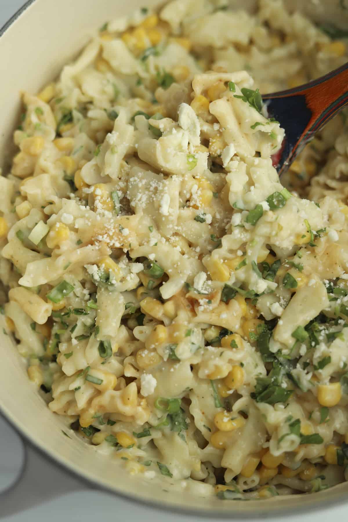 one pot elote pasta being stirred with a spoon