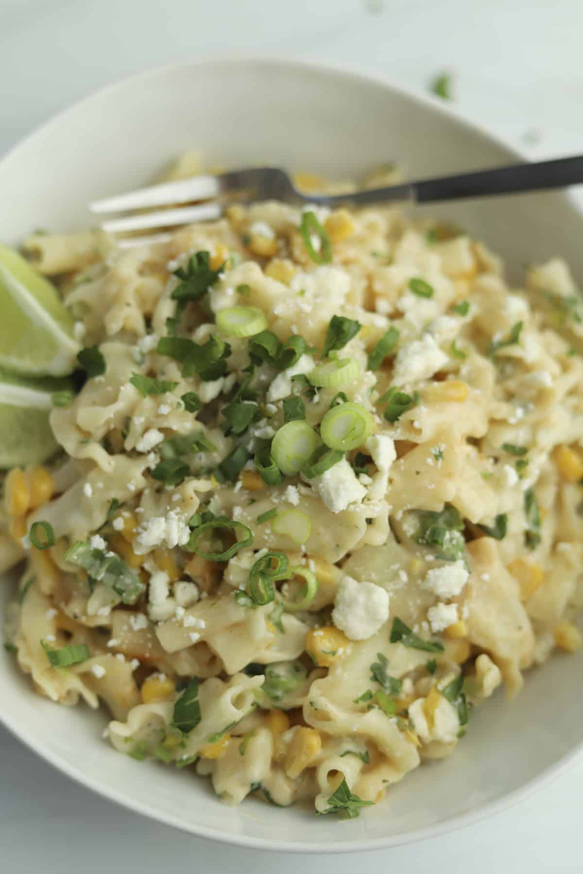 a bowl of elote pasta topped with green onions
