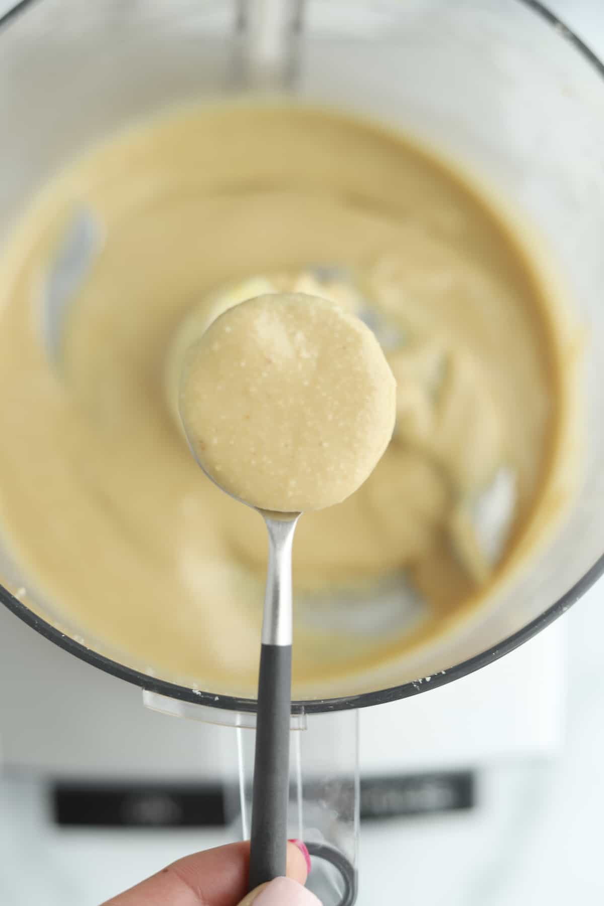 overhead of food processor with hazelnut butter on a spoon