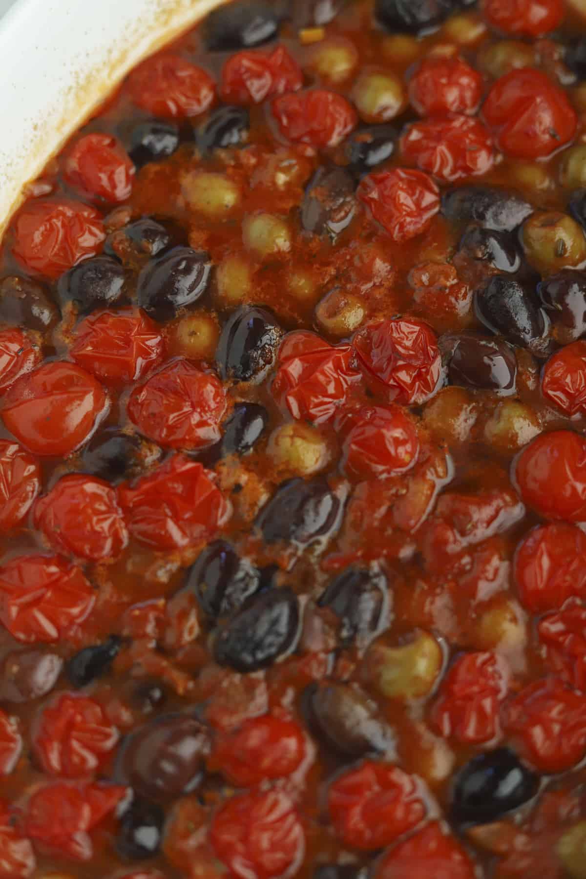 overhead of sauce with roasted tomatoes and olives