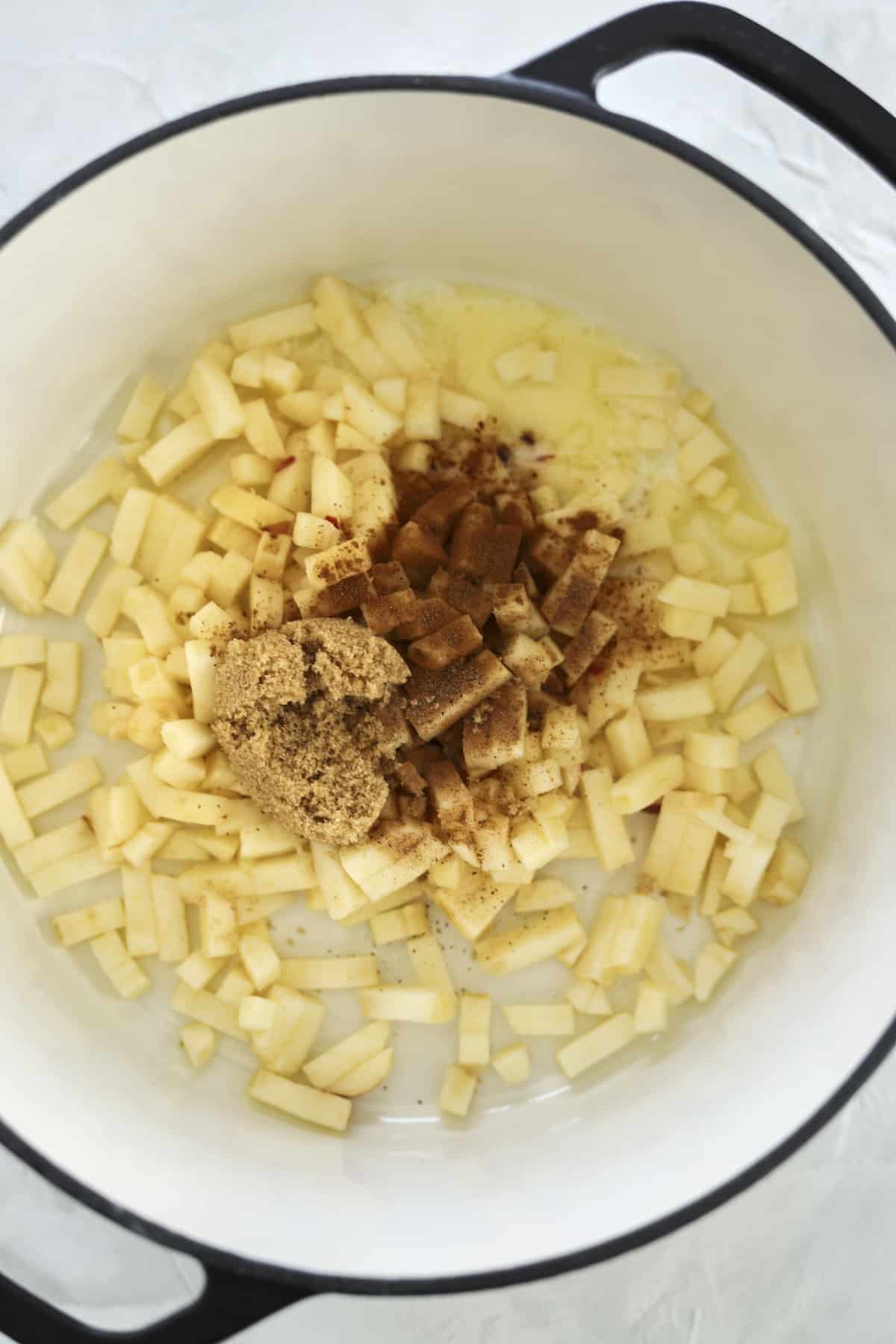 chopped apples in a pot topped with brown sugar and cinnamon