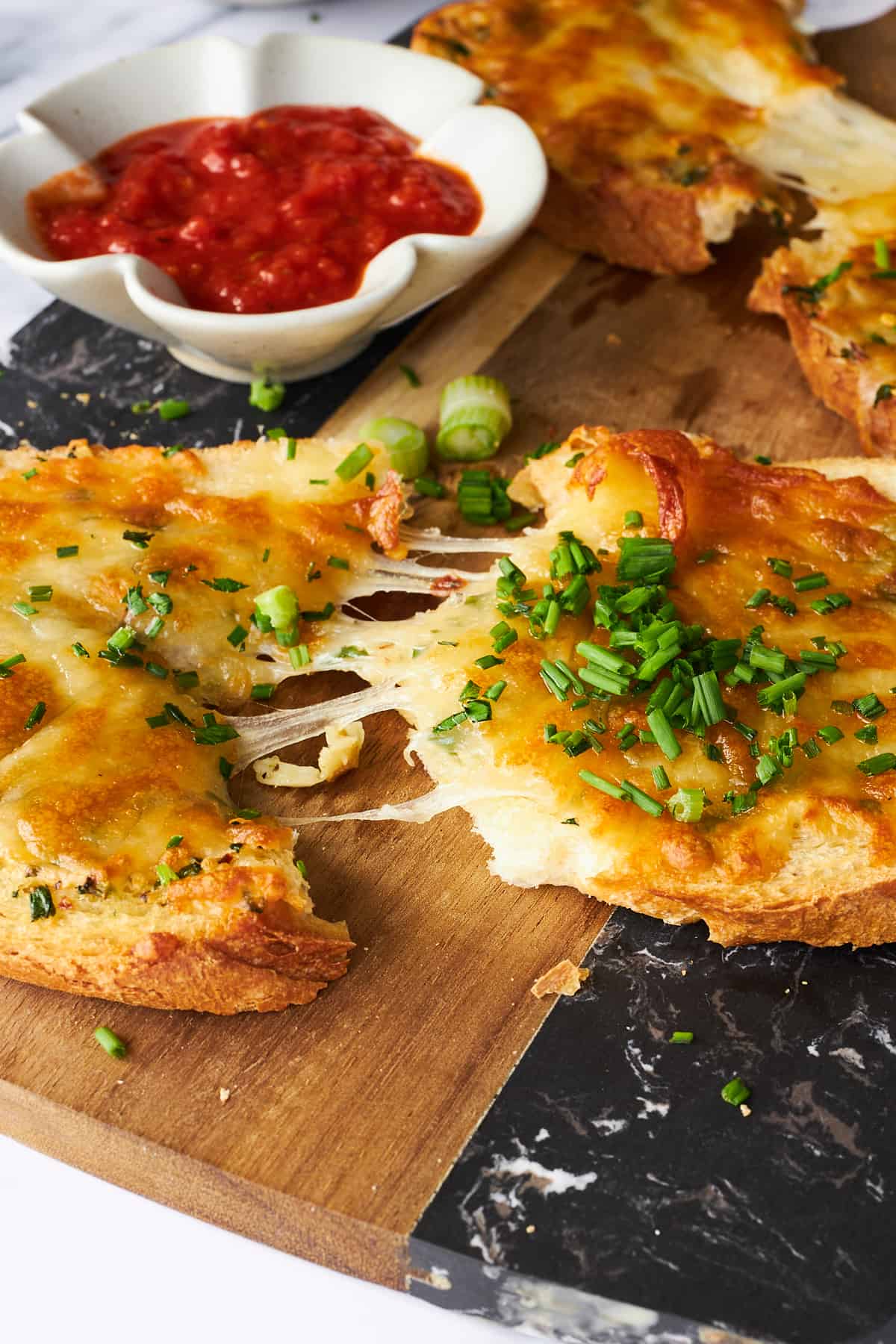 Cheesy garlic toast being pulled apart. 