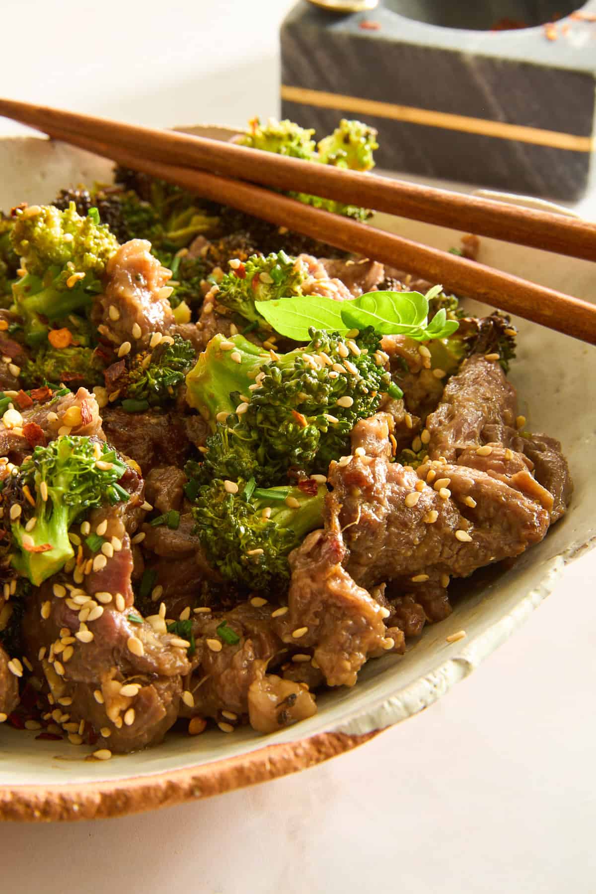 Air Fryer Beef and Broccoli in a bowl with chopsticks on top.