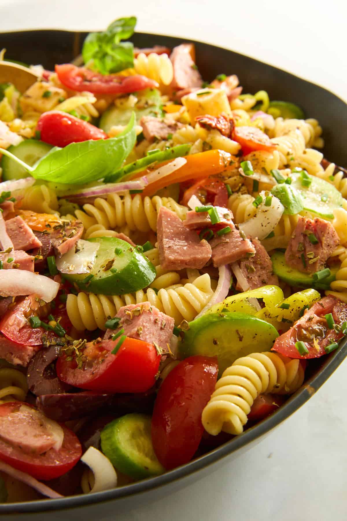 A bowl of Mediterranean pasta salad with salami. 