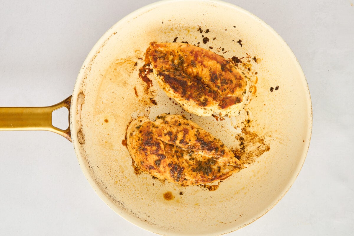 Chicken searing in a skillet.