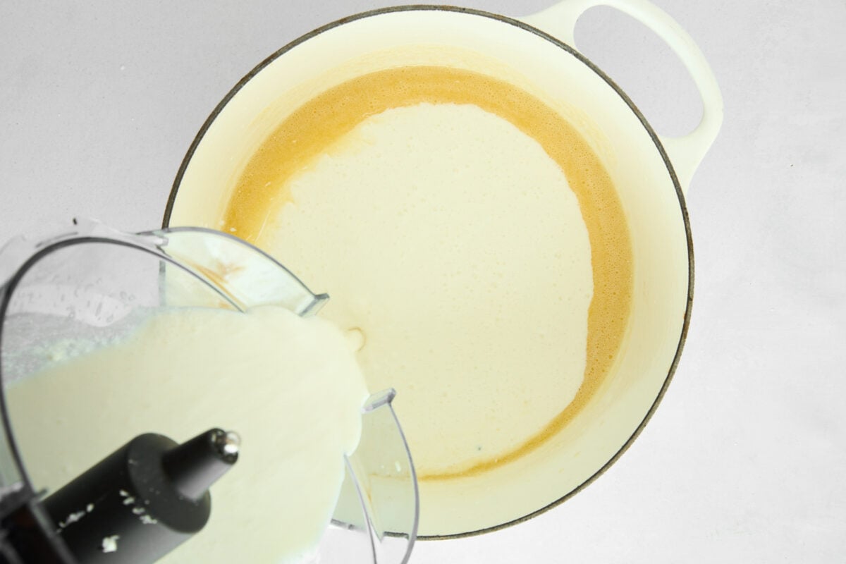 cottage cheese sauce being combined with melted butter in a skillet.