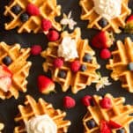 Mini waffles topped with whipped cream and fresh berries.