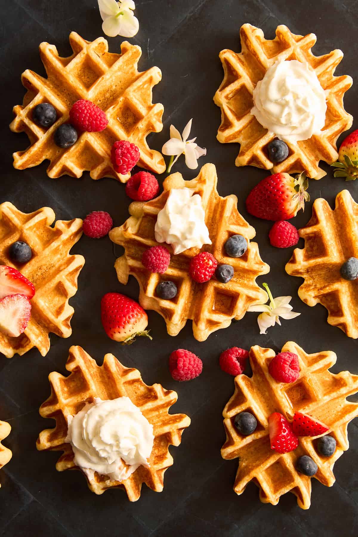 Mini waffles topped with berries and whipped cream.