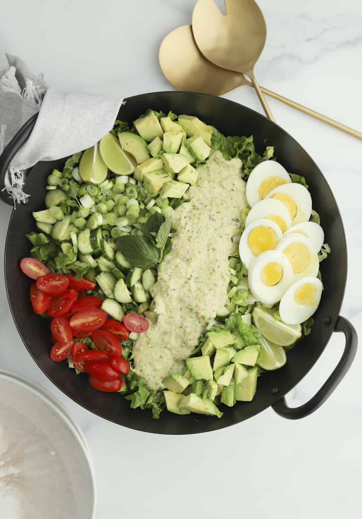 overhead cobb salad with serving spoons
