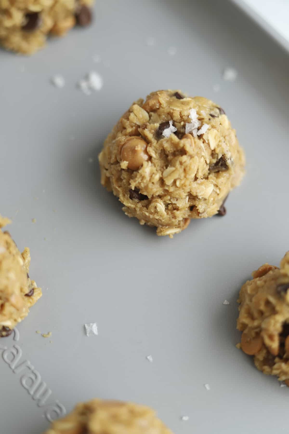 A ball of Crumbl Cookies Mom's Recipe copycat cookie dough on a baking sheet.